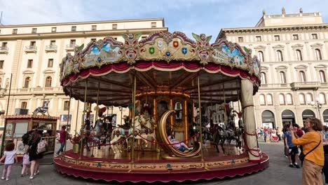 children and adults enjoy a carousel in a bustling square