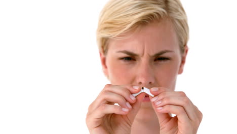 blonde snapping cigarette in half