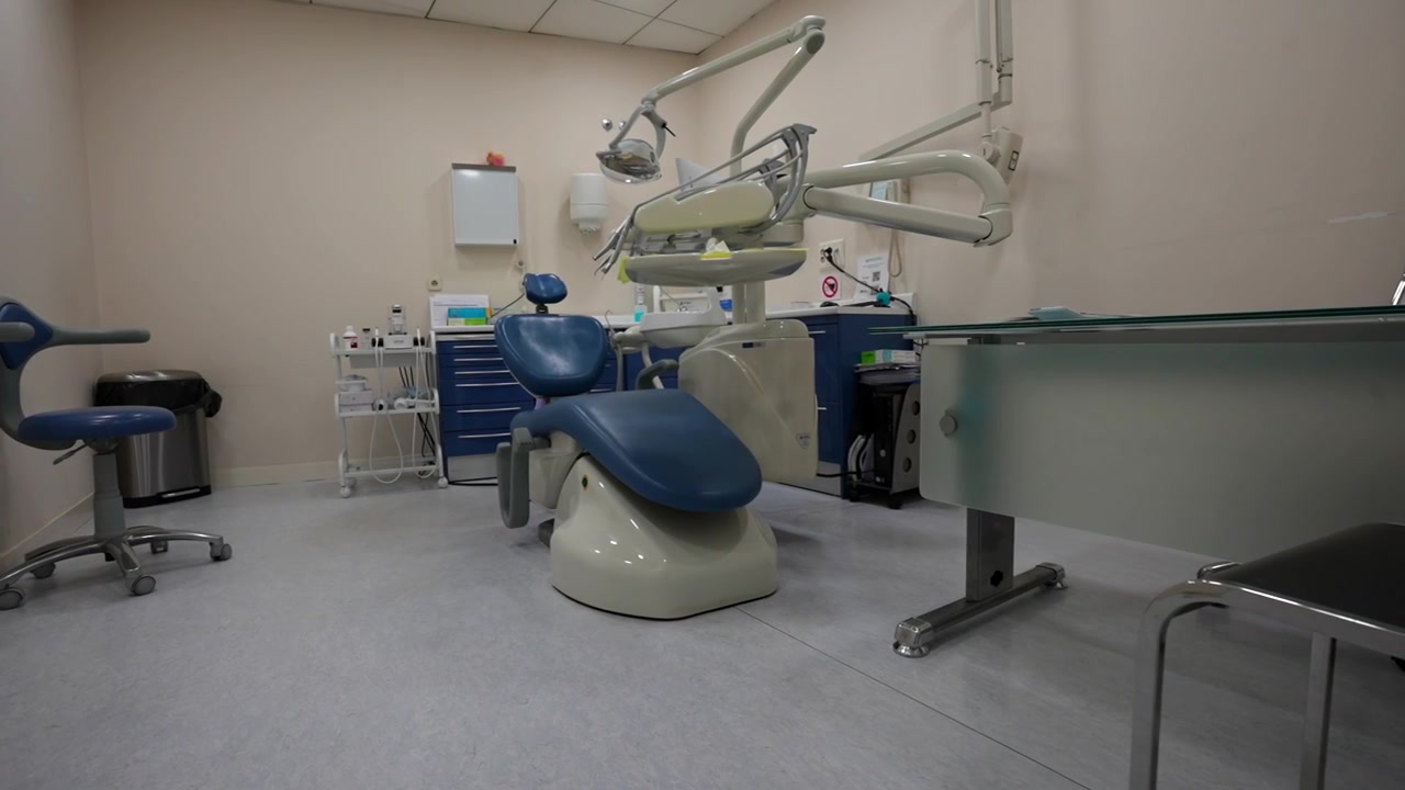 Empty dental clinic station set up with tools and chair ready for a patient, no people