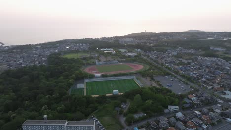 Drone-Aéreo-Vuela-Sobre-La-Prefectura-De-Fukui-Ciudad-De-Japón-Paisaje-Urbano-Campo-De-Fútbol-Y-Horizonte