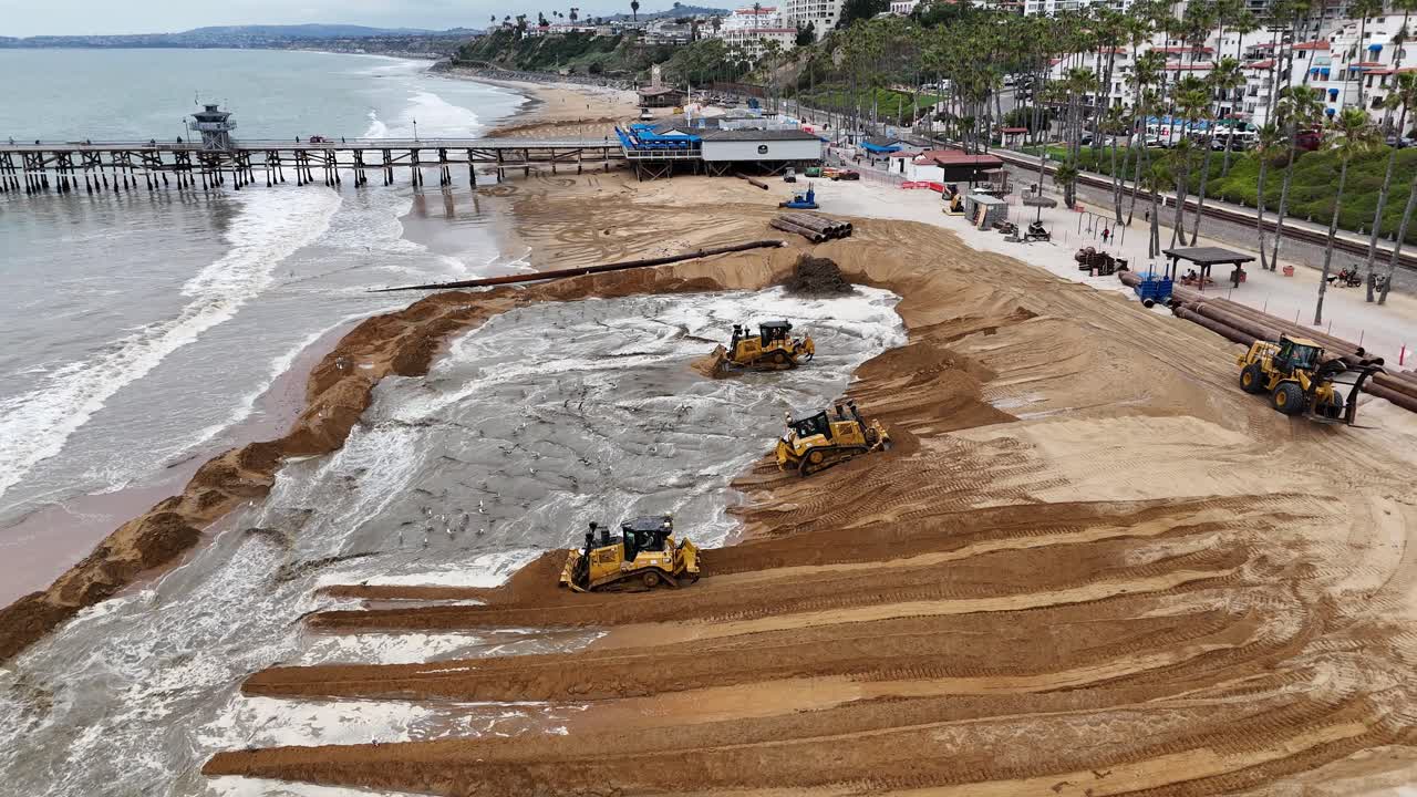 maquinaria pesada mueve arena durante un proyecto de restauración de playa en san clemente, california