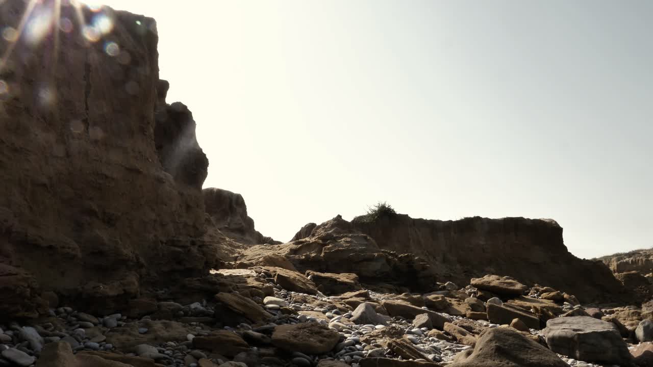 렌즈 플레어가 있는 가혹한 햇빛 속에서 발루치스탄의 건조한 바위 풍경
