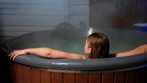 approaching a hot tub with a woman sitting in it. relaxation in spa outdoors in winter.