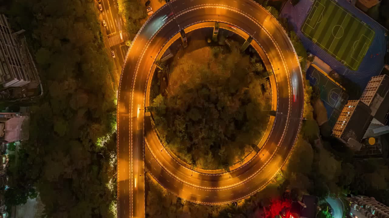 Aerial Night View of a Circular City Overpass and Sports Facilities