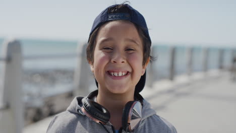 portrait young little boy smiling cheerful  enjoying summer vacation day on warm seaside beach slow motion