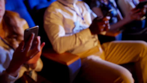 multi-ethnic business people using mobile phone during business seminar in auditorium 4 4k