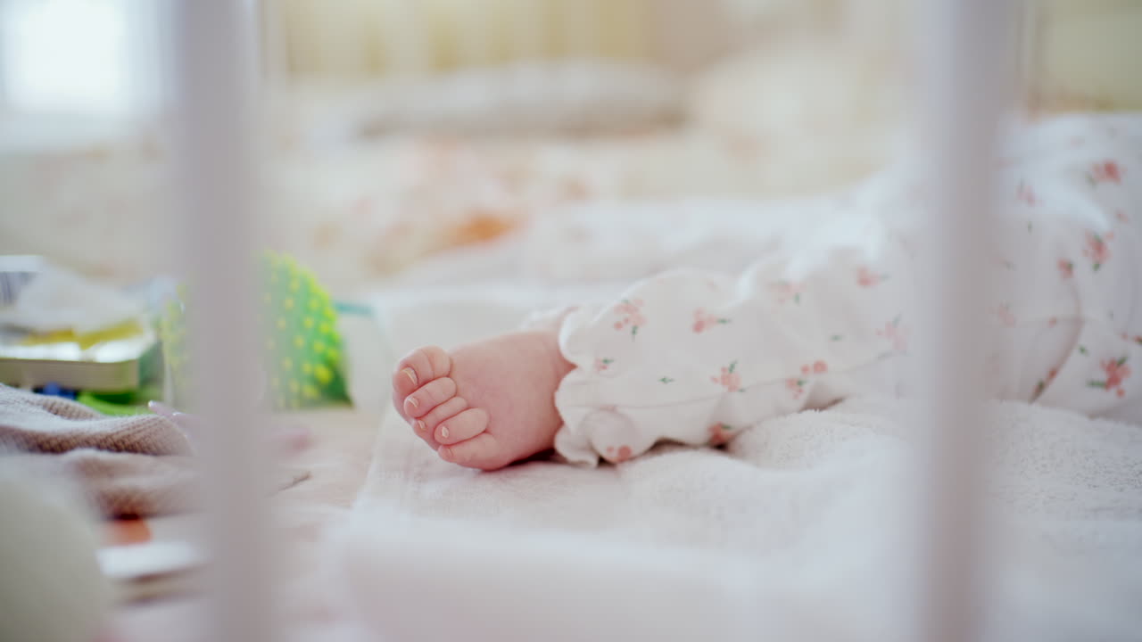 Primo piano dei piedini di un neonato che riposano su una morbida coperta all'interno di una culla