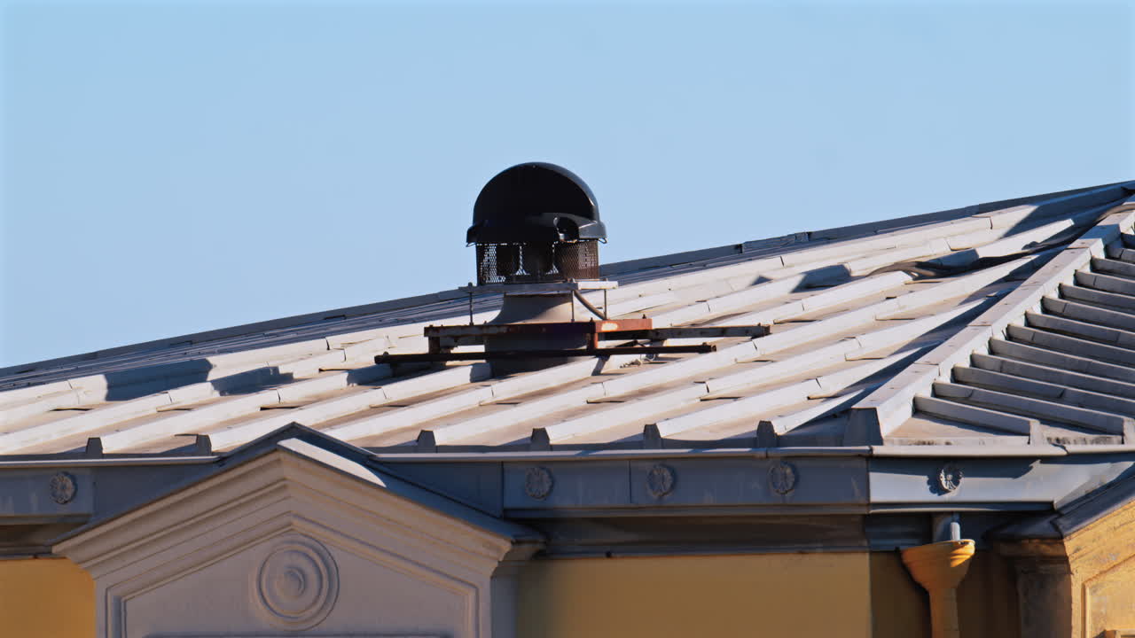 Close up of the facade and rooftop of a yellow building in Nice, France