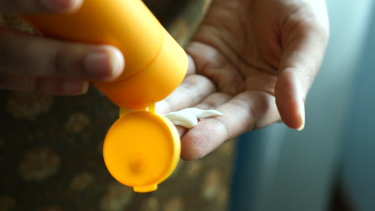 야외에서 자외선 차단 크림을 사용하는 사람의 손을 가 ⁇ 게