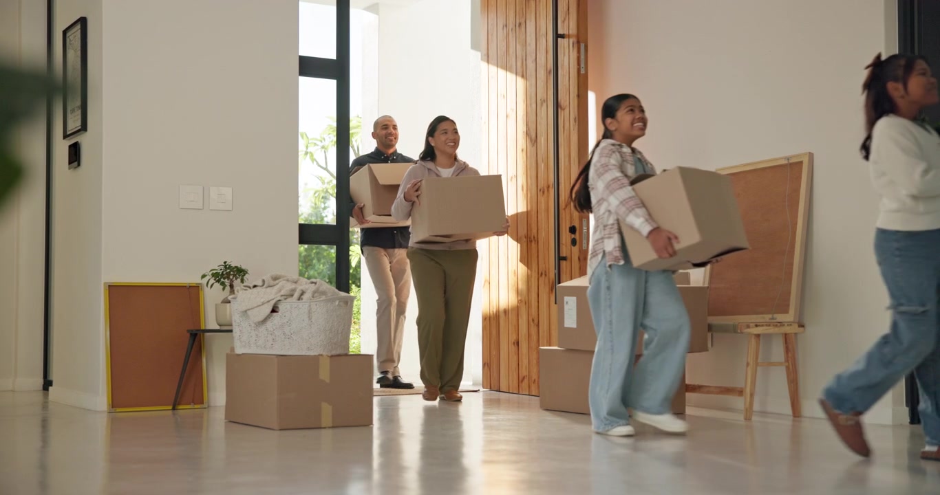 Happy Family Carrying Moving Boxes into New Home