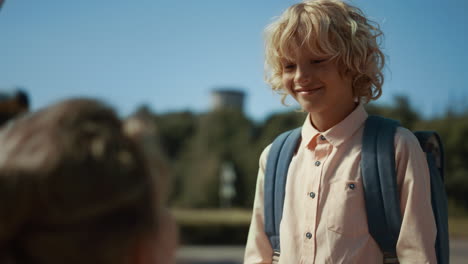 schoolboy giving high five to mom before studies close up. boy running to bus.