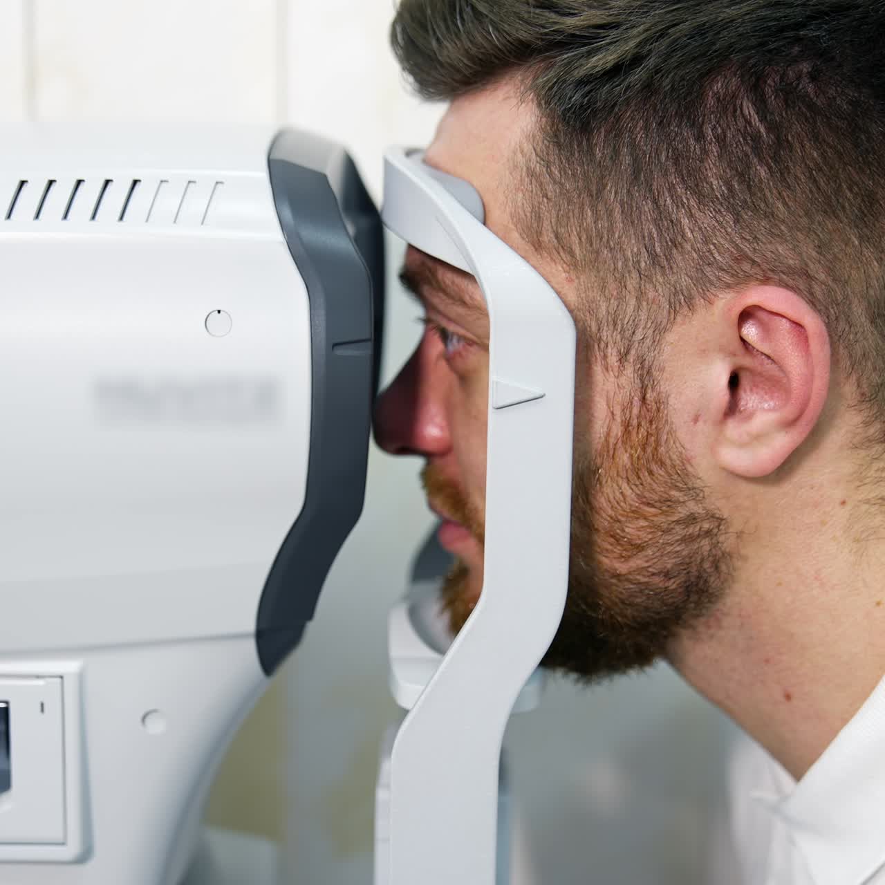 Male patient in ophthalmology clinic checks eyesight on special modern equipment. Selective focus on man`s face