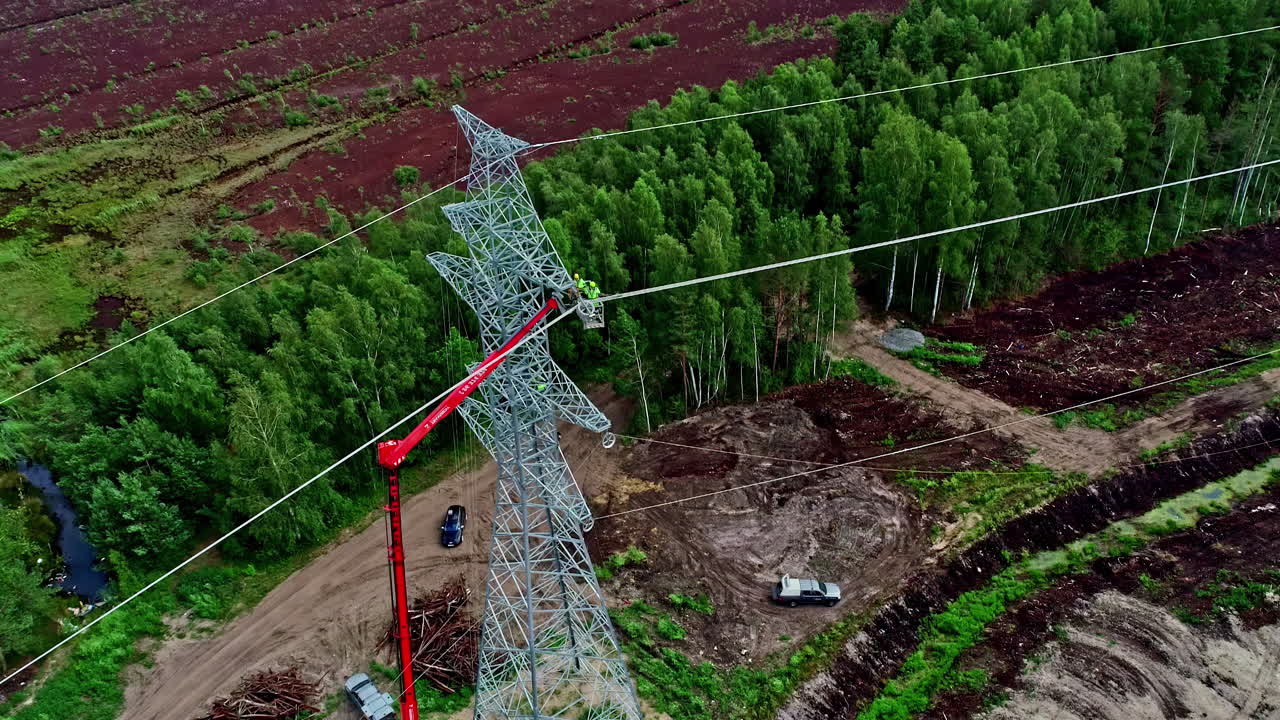 Aerial clip showing high voltage electric tower under maintenance