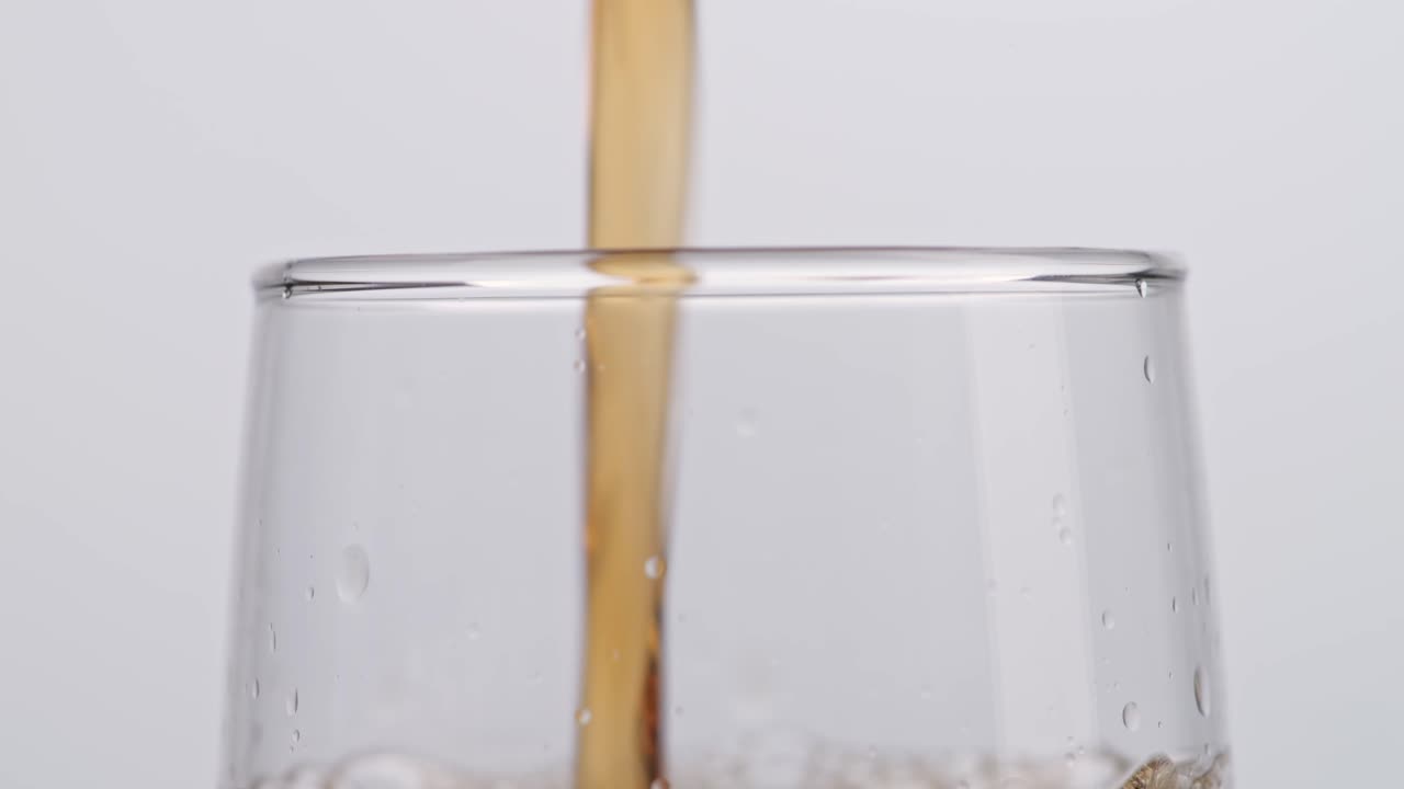 Close Up Of Fresh Cola Being Poured In To The Glass On White Background