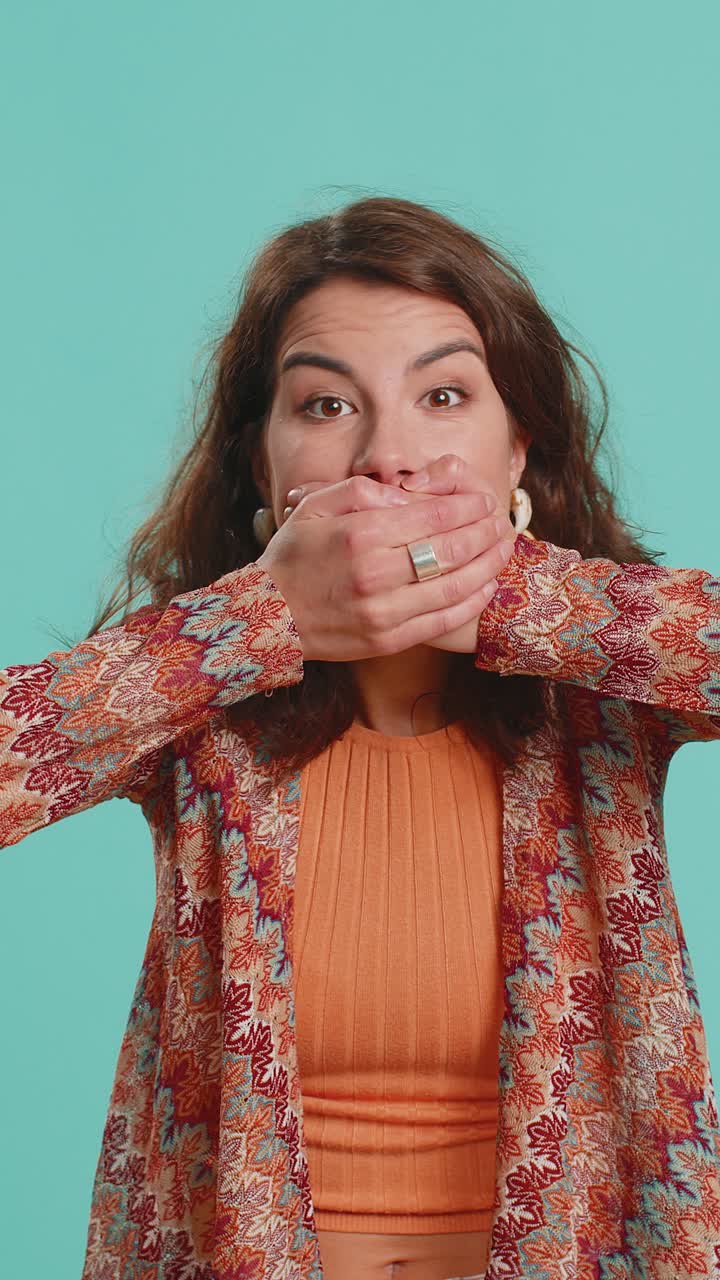 Young woman presses finger to lips makes silence gesture sign do not tells secret stop gossip