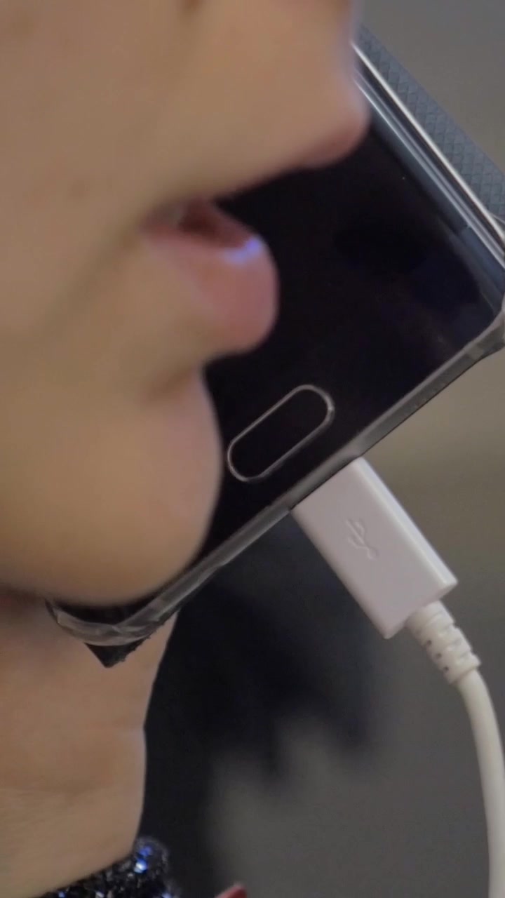 Donna che parla al telefono nell'area ritiro bagagli dell'aeroporto