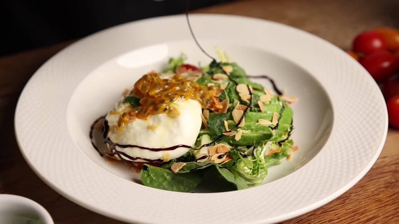 Rưới sốt balsamic cô đặc lên món salad Burrata và bơ tươi