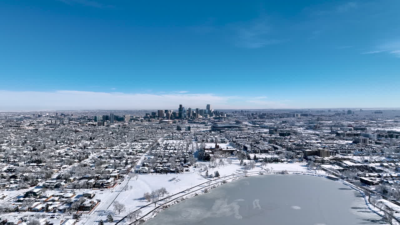 Toma aérea de dron de gran altura alejándose del paisaje urbano de Denver durante una tormenta invernal