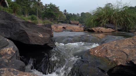 flowing river with rocks in maha oya, pinnawala, peaceful scenery