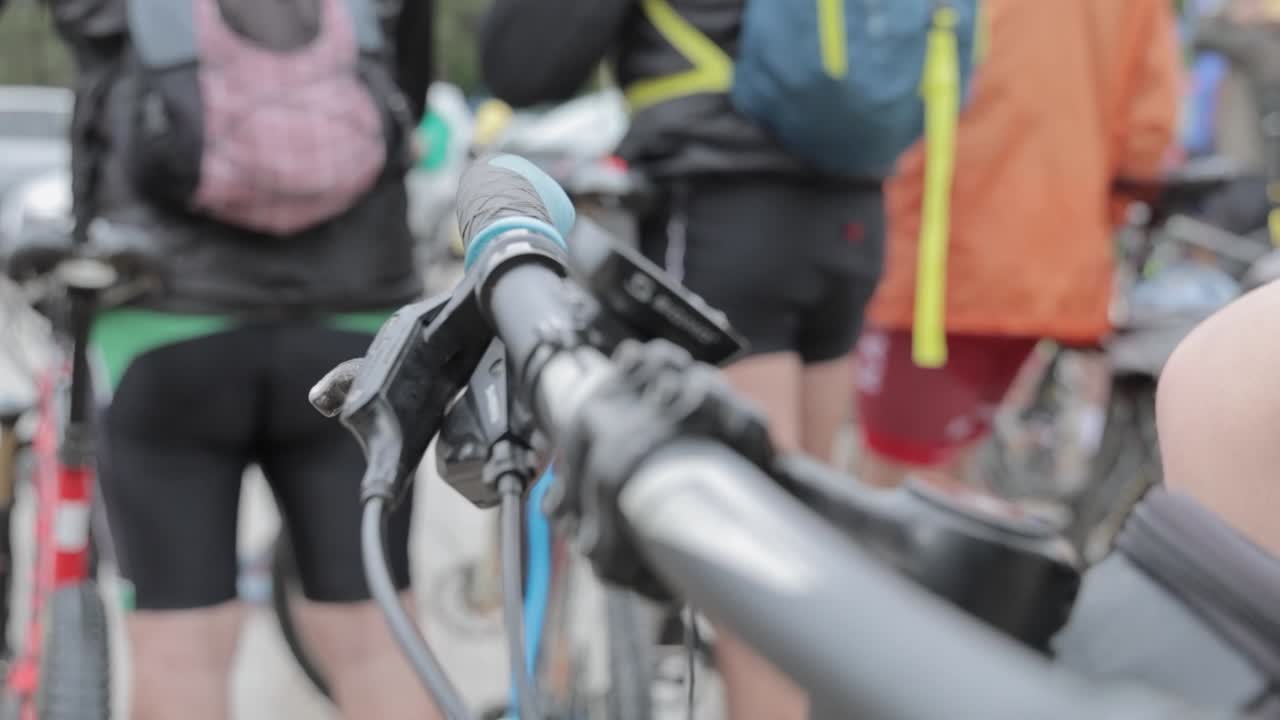Biker with glove put hand on a mountain bike handlebar