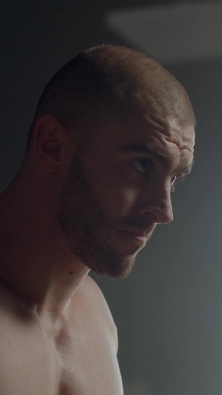 Uomo atletico concentrato che guarda verso il basso in palestra