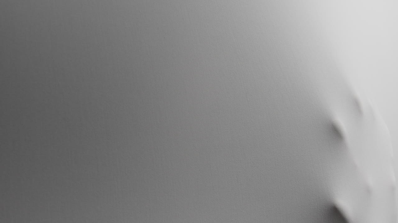 A scary face and hands appear from the white surface