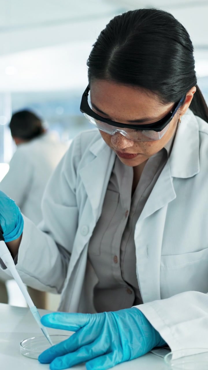 Scienziato che usa una pipetta per trasferire liquido in laboratorio