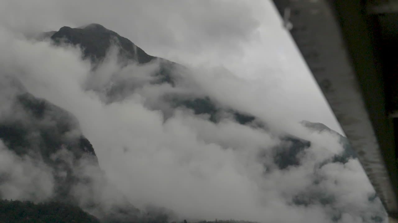 천천히 움직이는 비방울이 배 에서 떨어지는 전면에서 뒤에 구름이 가득한 산에 초점을 맞추고 - 의심스러운 소리, 뉴질랜드