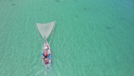 Aerial-shot-of-a-traditional-shrimp-fisherman-on-small-wooden-boat-in-Thailand