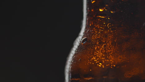 close up of condensation droplets on revolving bottle of cold beer or soft drink 1