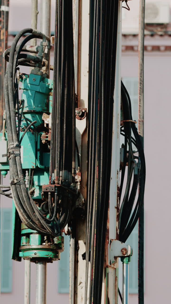 Close up of industrial drilling equipment with hydraulic cables and metal framework