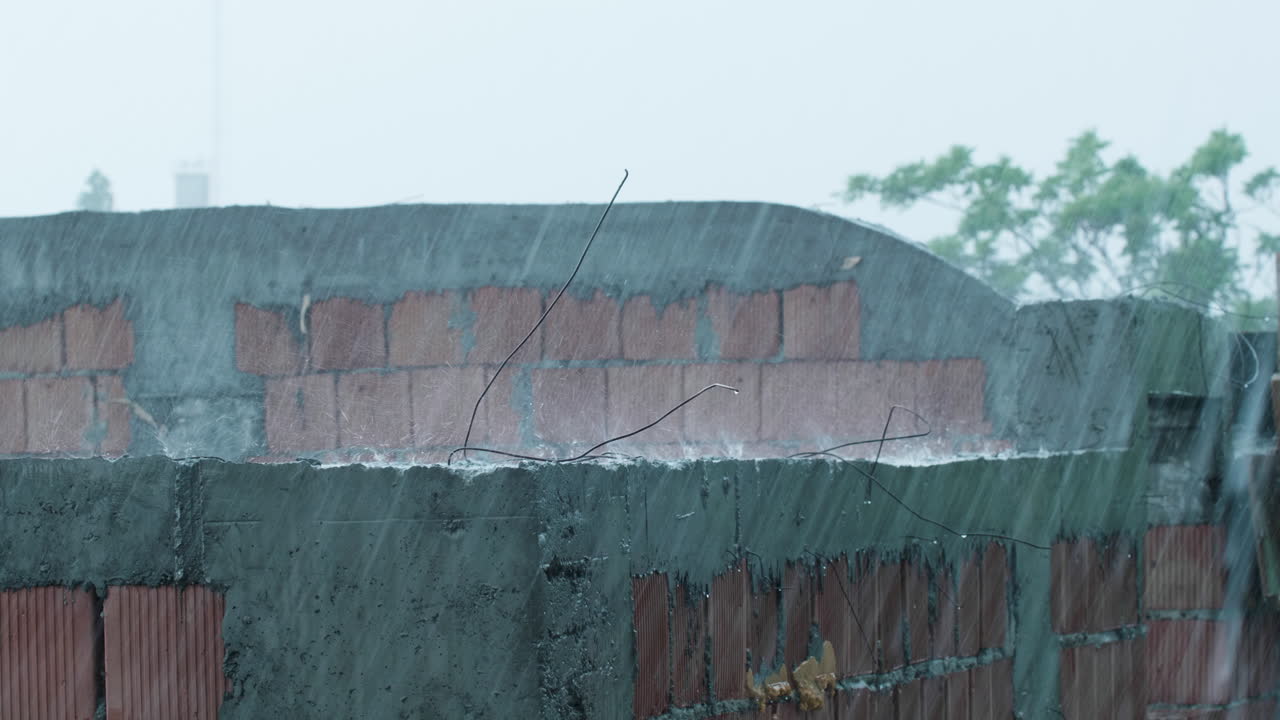 Rain falling on a brick wall under construction