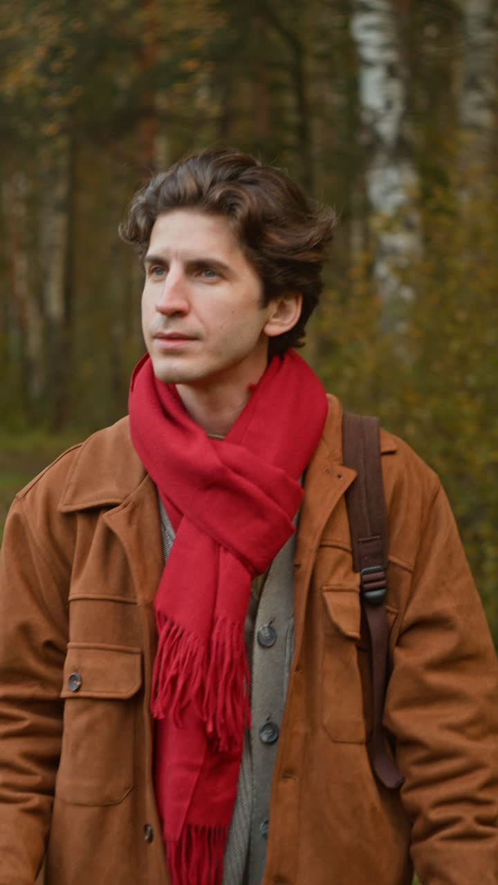 Man in red scarf and brown jacket outdoors