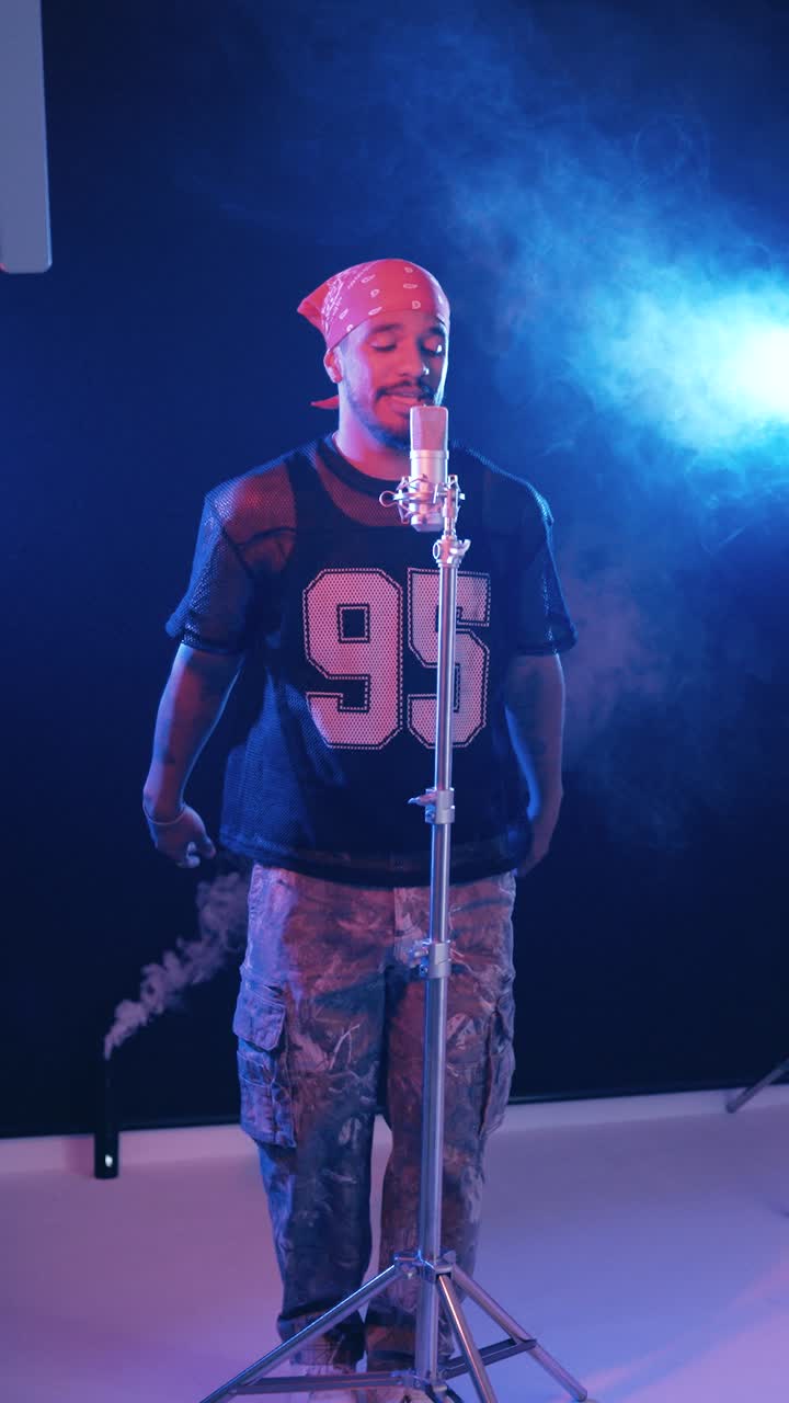 Afroamerikansk rapper synger i en professionel mikrofon. Vertikal