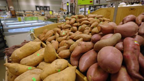 potatoes and sweet potatoes on display in a grocery store