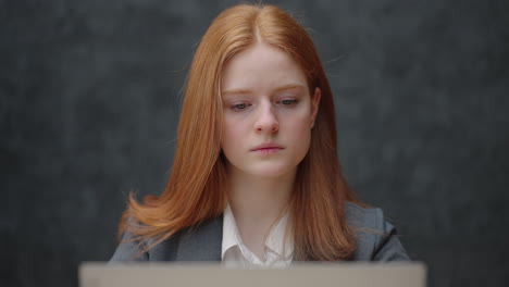 Thoughtful-concerned-redheaded-woman-working-on-laptop-computer-looking-away-thinking-solving-problem-at-office-serious-woman-search-for-inspiration-make-decision-feel-lack-of-ideas