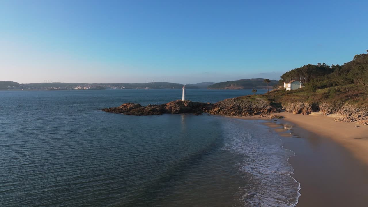 Quiet Sandy Beach Near The Fazo baliza do Lago Lighthouse In Muxia, A Coruña, Spain. - aerial shot