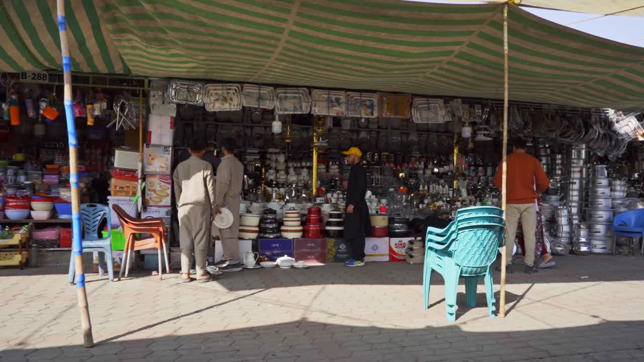 Vibrant market atmosphere in Islamabad with crowds of people bustling around street vendors and stalls to purchase ar crockery shop.