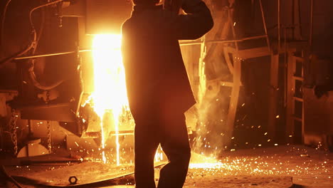 steelworker pouring hot metal