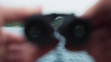 Fingers-Holding-Mini-Binoculars-By-The-Waterfront