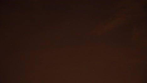 the timelapse captures the beautiful transition of the sky from blue to red with passing clouds illuminated by the lights of the city below