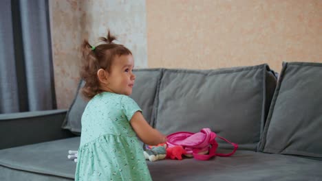 a playful child engages with colorful toys on a couch, embracing imagination and joyful exploration in a cheerful indoor setting