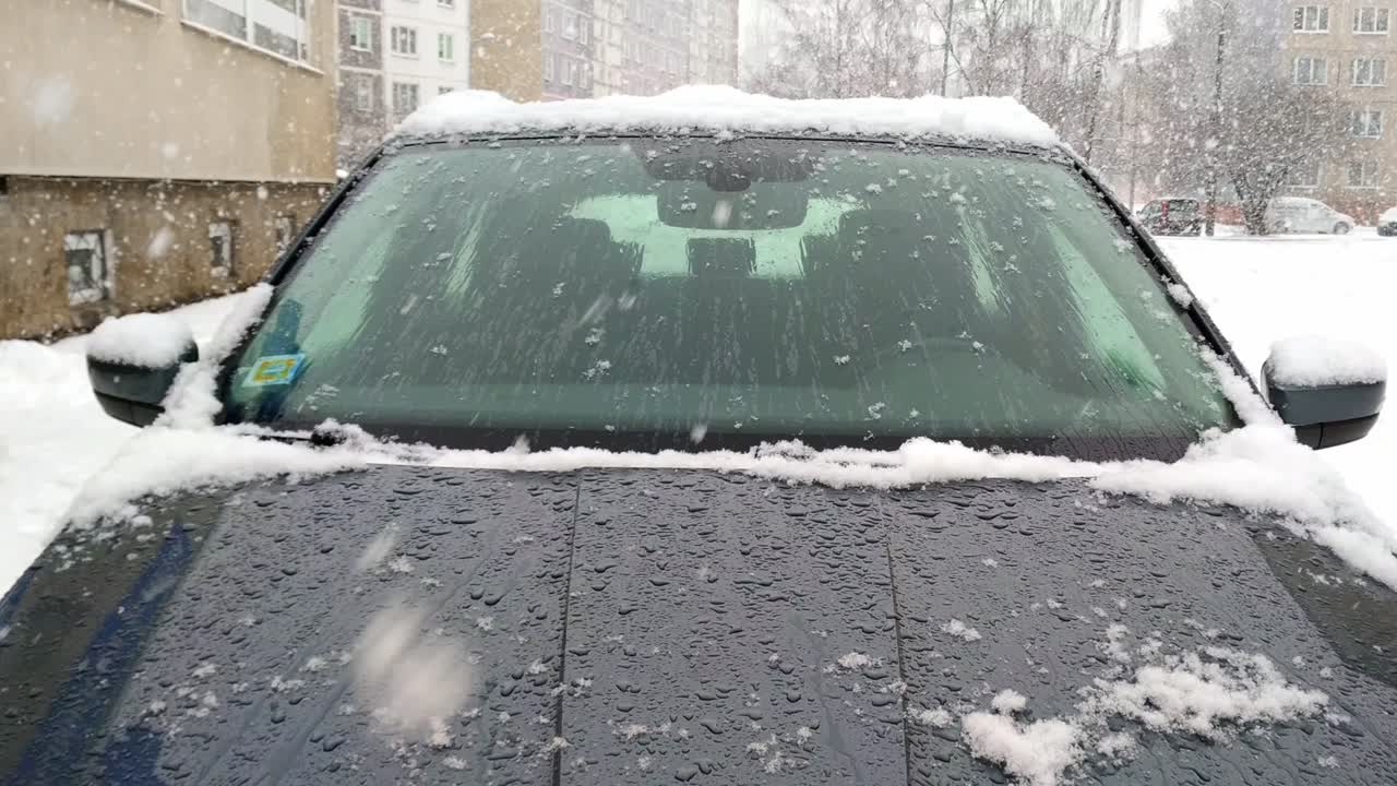 강설 중 세단 자동차 보닛의 눈 안개 습기