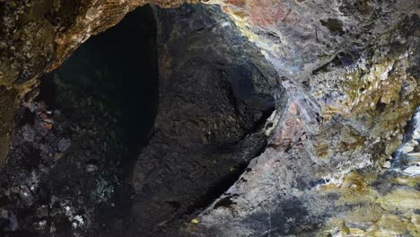 panorámica derecha tomada dentro de una cueva volcánica que revela un estanque subterráneo, algar do carvao