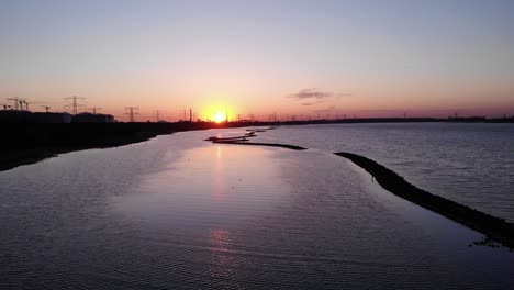 Schöne-Sonnenuntergangsansicht-Mit-Vögeln,-Die-über-Ruhige-Gewässer-Bei-Maasvlakte-In-Brielse-Meer,-Niederlande-Fliegen