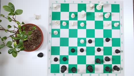 lone player playing chess on green and white checkered chessboard