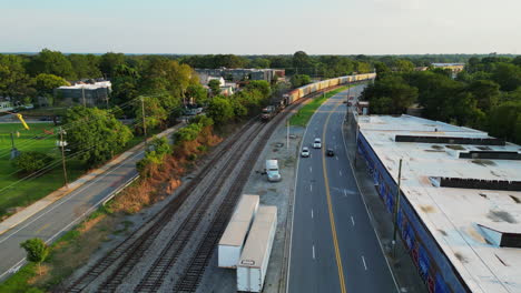 aerial view of heavy a long freight train passing through suburb