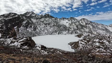 hombre de nieve con cabeza amarilla en la orilla de un lago de alta altitud