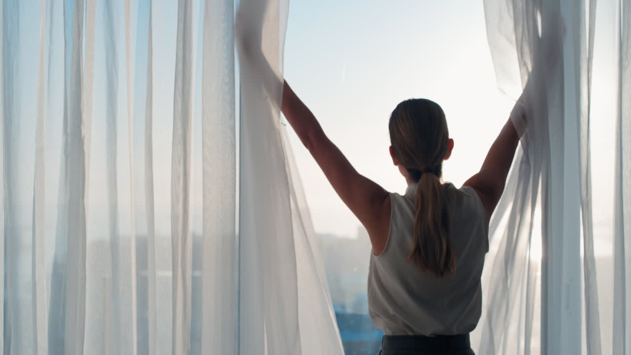 사업가 여성은 호텔 방에서 커튼을 열고 신선한 새로운 날을 창문 밖으로 바라보고 성공적인 독립적인 여성 계획 태양이 뜨면 앞으로