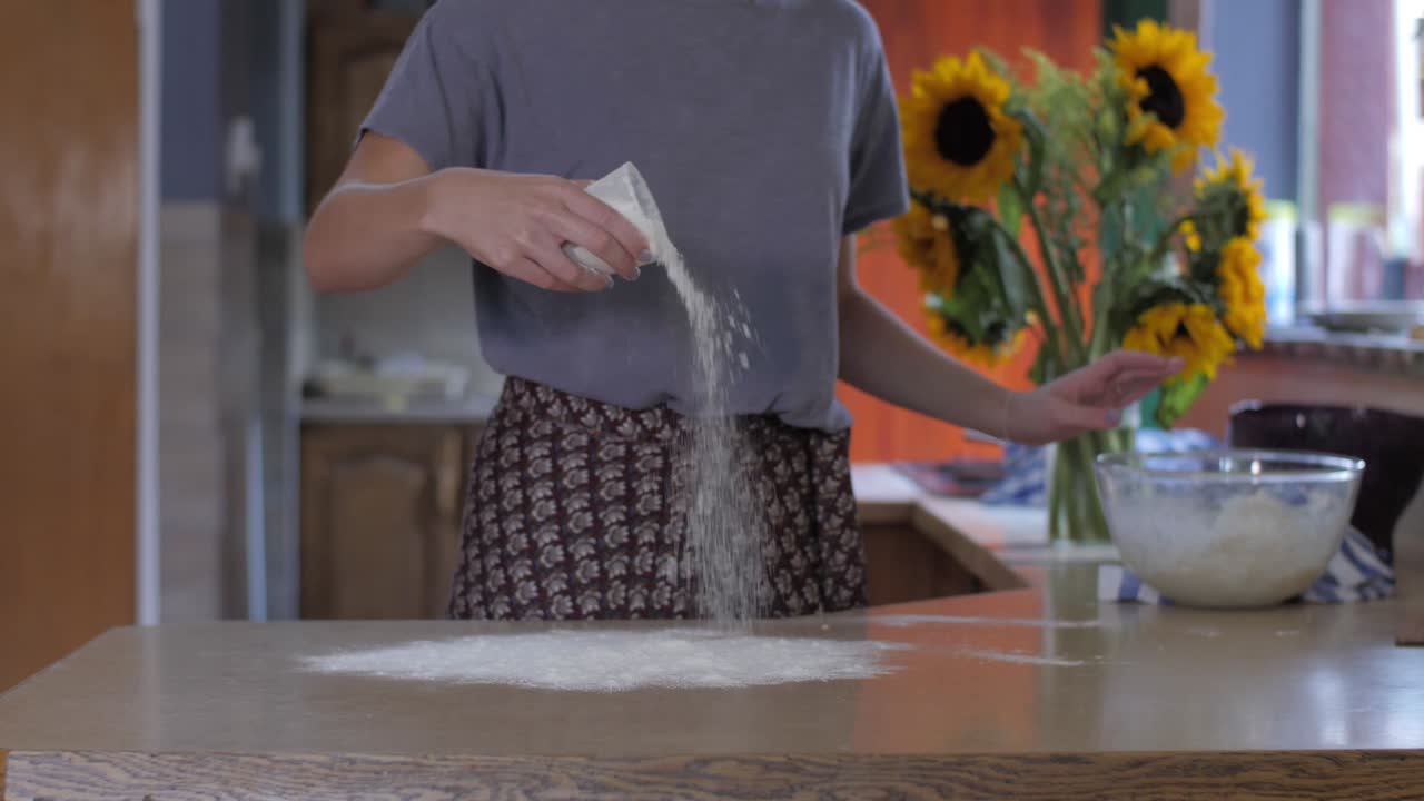 Woman flouring a surface in a kitchen